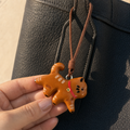 Close-up of handmade walking cat bread bag charm with brown leather cord