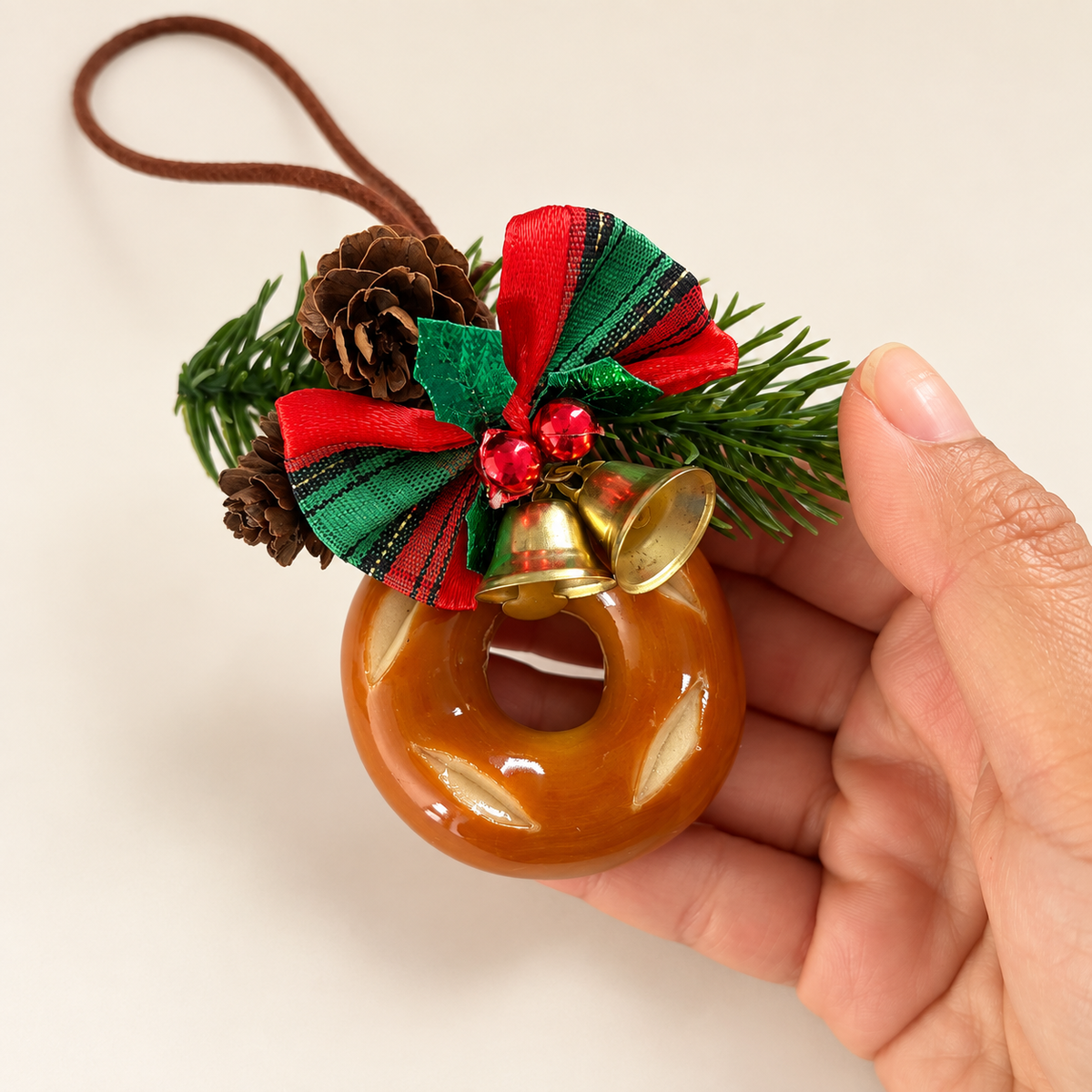 Bagel Christmas ornament held in hand for scale