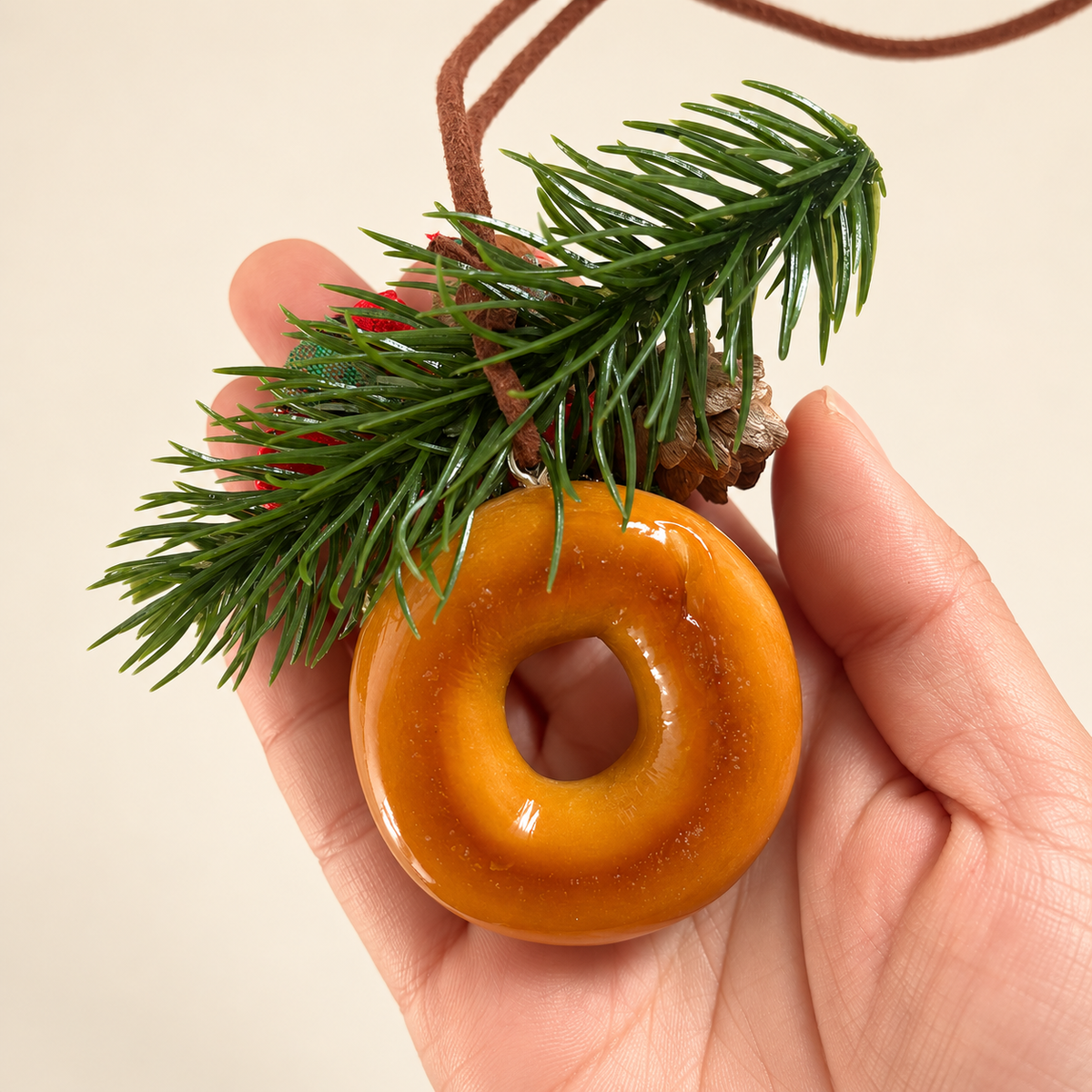 Back view of bagel ornament and pine sprig held in hand