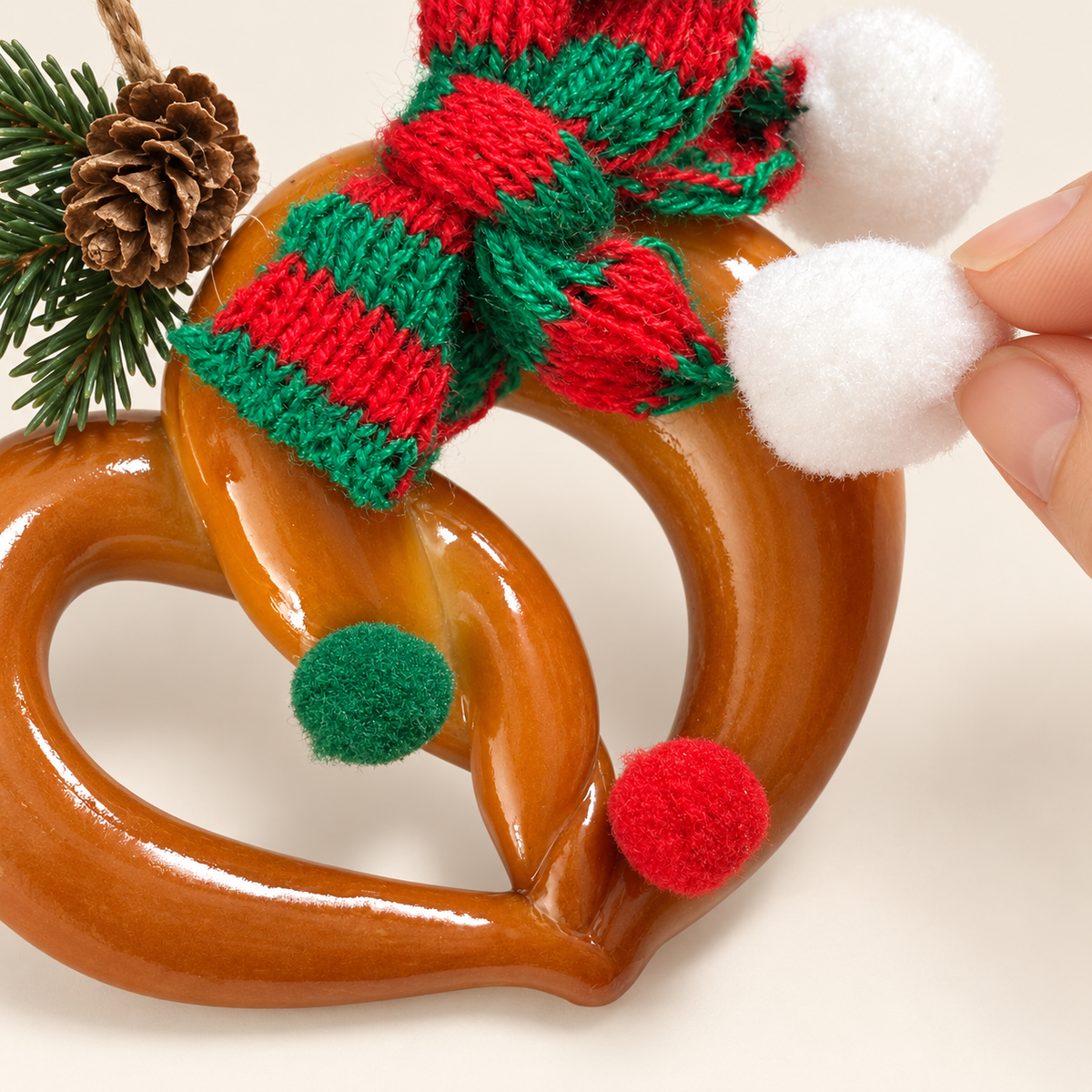 Macro detail of fluffy pom-poms and knitted scarf on Christmas Heart Pretzel ornament