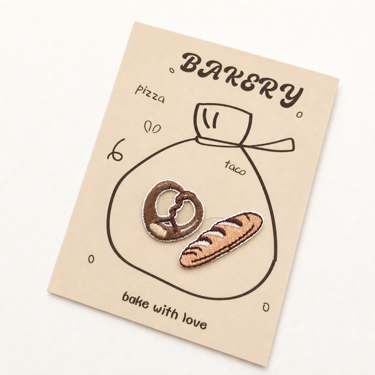 Pretzel and baguette embroidered patches on bakery display card