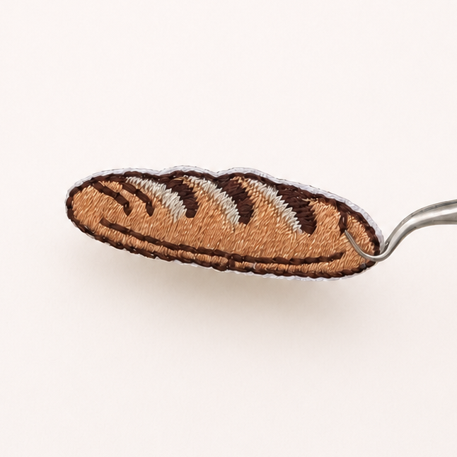 Baguette embroidered sticker patch held with tweezers