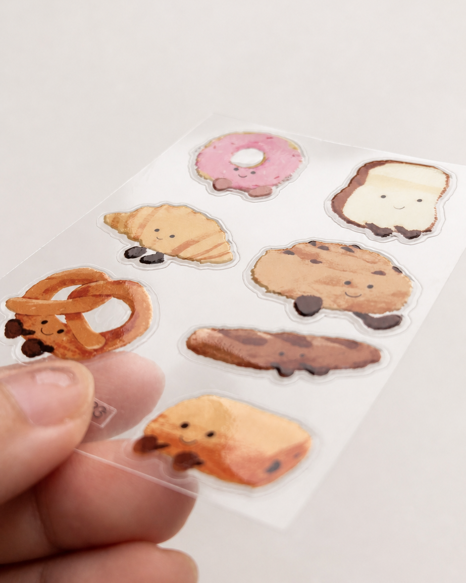 Angled close-up showing the glossy raised texture of Little Bread Buddies stickers