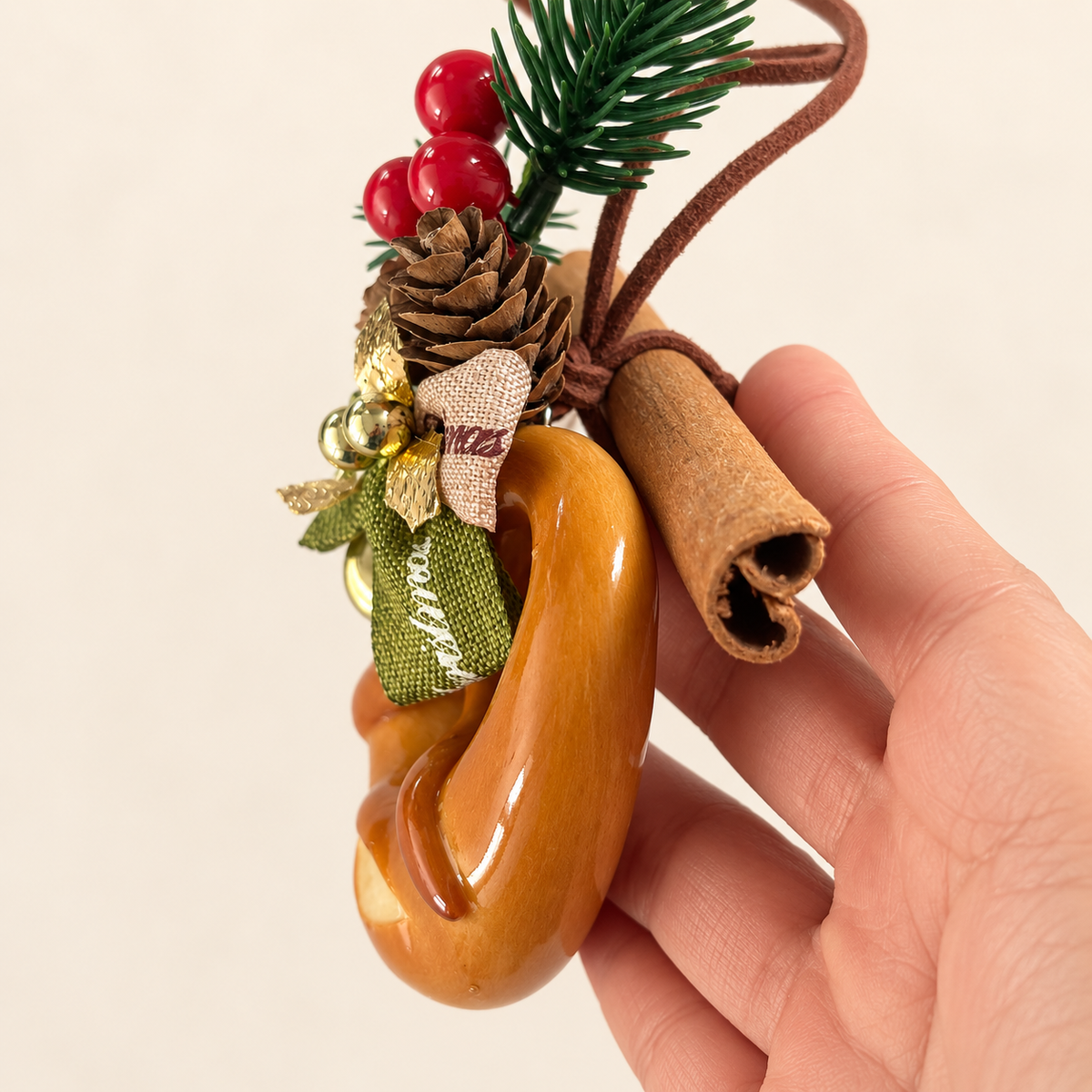 Side view in hand showing the real cinnamon sticks and layered ornament details